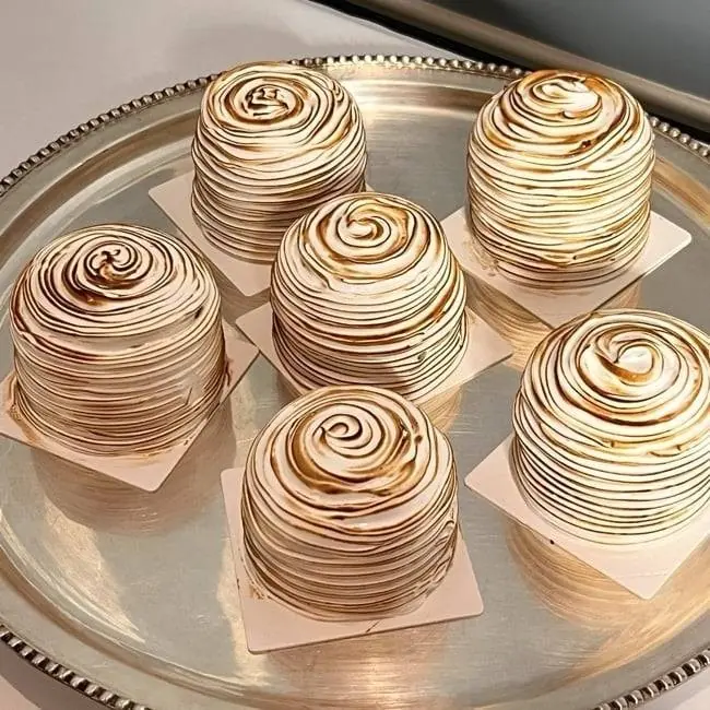 Torched meringue cakes on a silver platter